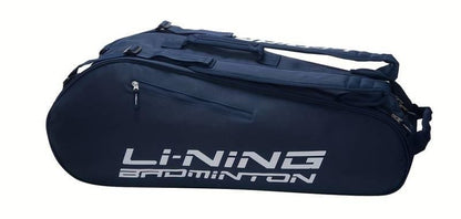 The Li-Ning Thunder 6 Racket Badminton Bag in Petrol Blue features a spacious design with two compartments, including one specifically for rackets. It sports cushioned double backpack straps and a side handle to ensure comfortable carrying of your badminton gear, and showcases a striking dark blue color with white text.