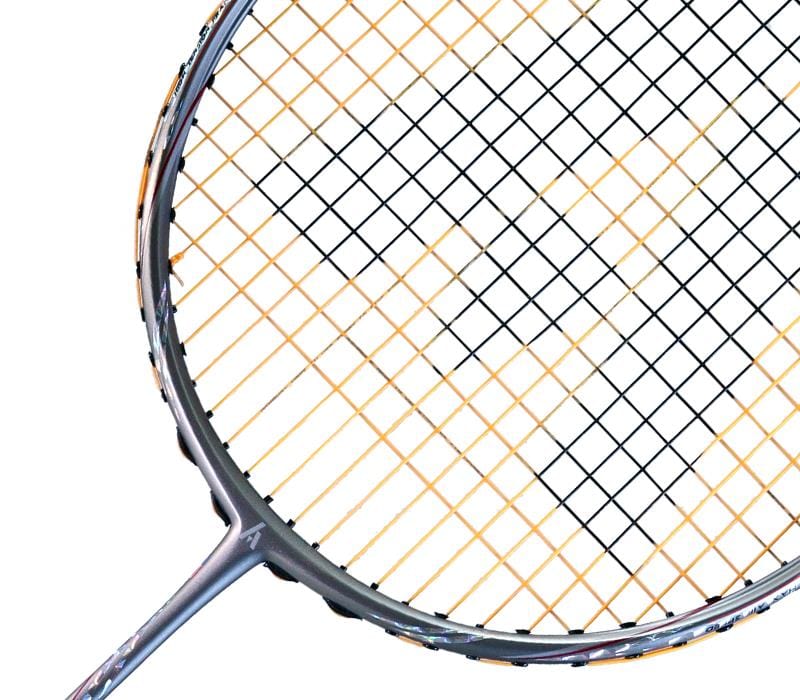 Close-up of an Ashaway Phantom Shard 3 3U Badminton Racket in Orange, showcasing its head with Zymax 68TX strings forming a colorful geometric grid. The metallic frame shows wear from frequent play, enhanced by Shardtech technology for durability.