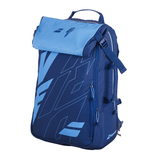 The Babolat Pure Drive Backpack - Blue by Babolat showcases a stylish blue and navy two-tone design, complete with a flap closure and convenient top handle. It offers multiple zippers, side pockets, and a geometric pattern on the front, making it an ideal choice for carrying badminton essentials.