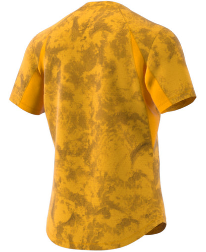 Back view of the ADIDAS Paris Men's Freelift Badminton T-Shirt in a gold and yellow camouflage design. This short-sleeve athletic tee includes raglan sleeves, a slightly rounded hem, and HEAT.RDY technology to ensure comfort during intense matches.