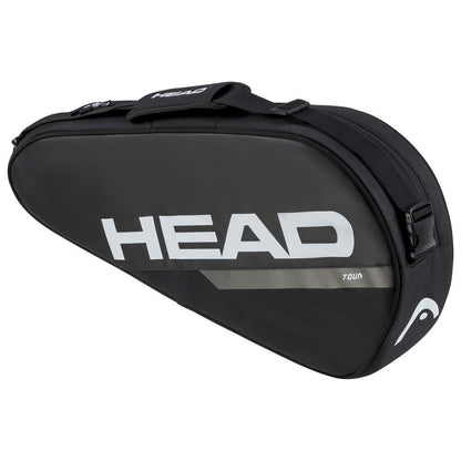 The HEAD Tour Badminton Racket Bag S in black and white prominently features the brand name "HEAD" and is highlighted by its spacious compartment, curved design with a zippered closure, and an adjustable shoulder strap for effortless carrying.