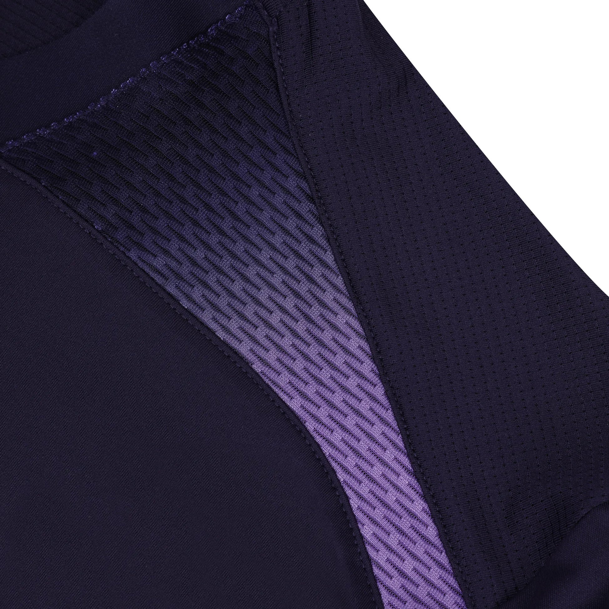 A close-up view of the Le Coq Sportif Pro Men's Badminton T-Shirt reveals its textured, gradient pattern, echoing dynamic styling. The garment predominantly features a rich dark blue hue that seamlessly transitions to deep purple, illustrating fluid movement. Made from breathable polyester, it offers a smooth and woven finish typical of Le Coq Sportif's quality craftsmanship.