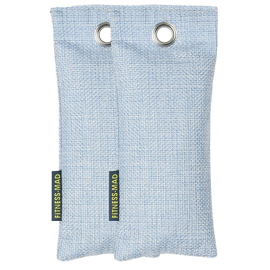 A pair of light blue, rectangular fabric bags featuring metal grommets at the top. Each bag is adorned with a small black and green label displaying "FITNESS MAD." The woven texture is infused with active charcoal, making it ideal for use as a Fitness Mad Sports Odour Absorber or deodoriser.