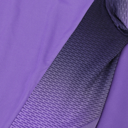 A close-up of a textured fabric featuring a gradient from purple to dark purple evokes the design of the Le Coq Sportif Pro Mens Badminton T-Shirt in Chive Blossom by Le Coq Sportif. The pattern of small, horizontal lines on breathable polyester materials enhances fluidity in movement, creating an appealing transition of colors and textures.