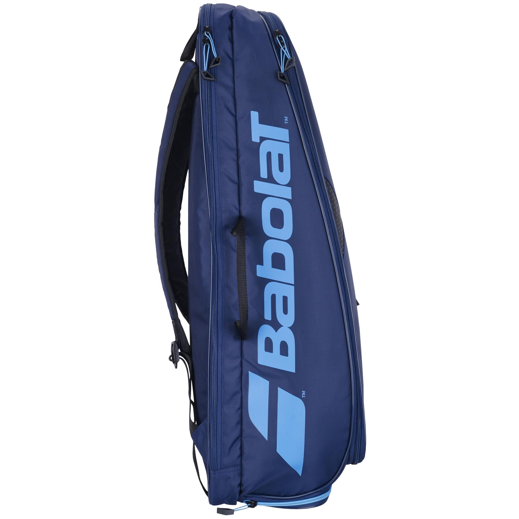 The Babolat Backrack 3 badminton bag in dark blue stands upright, displaying the Babolat brand name prominently along its side in large light blue letters. Constructed from recycled polyester, it includes multiple zippered compartments and shoulder straps for added convenience.