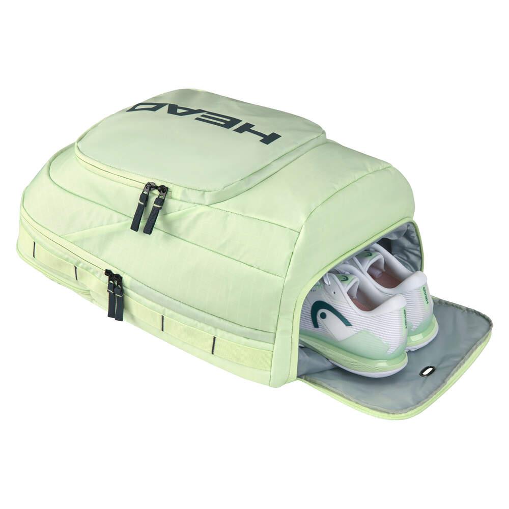 A light green HEAD Pro 30L Badminton Backpack with "HEAD" prominently displayed on top, made from durable ripstop fabric. This backpack includes multiple zippered compartments and a ventilated shoe section containing a pair of white athletic shoes accented in green and blue.