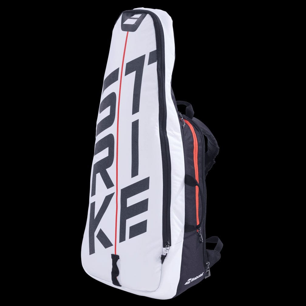 This Babolat Pure Strike Backpack in white and red with black undertones is perfect for holding rackets. The vertical brand name adds a distinct touch, and it offers various compartments including an isothermal insulated section for badminton essentials, along with a convenient carrying handle.