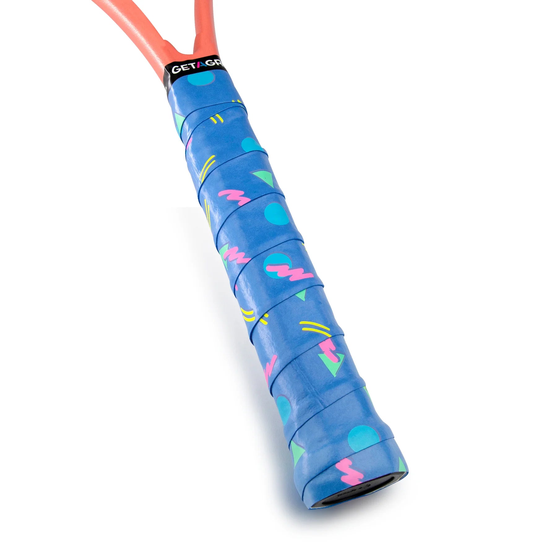 A close-up of a badminton racket handle wrapped in the vibrant blue Get A Grip Cutting Shapes Badminton Overgrip. This non-slip accessory showcases colorful geometric patterns, including pink zigzags, green circles, and yellow lines. The top of the grip features a black band with the brand name "GET A GRIP.