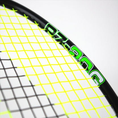 Close-up of a badminton racket's head from Karakal, highlighting bright yellow strings and a glossy black frame. The frame displays green numbering and details, evocative of an Isometric Head design, set against a plain white background. This is the Karakal BZ 20 2.1 Badminton Racket in Black/Green.