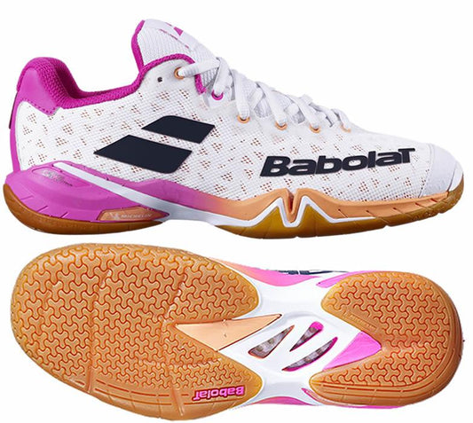 Presenting the Babolat Shadow Tour Women's Badminton Shoes in white and pink. These shoes feature a breathable design, DCS technology for improved comfort, and a gum sole with patterned tread for enhanced grip. The prominent brand logo highlights their Michelin collaboration heritage.