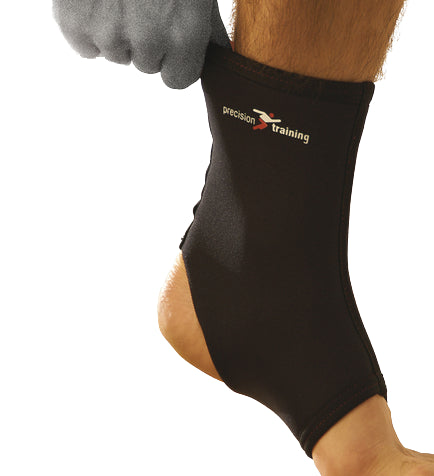 A person wearing a Precision Neoprene Ankle Support, featuring the "Precision" branding, adjusts the snug brace that encases the ankle like a compression sleeve. Offering stability while leaving the toes exposed, it is ideal for recovering from ankle sprains.