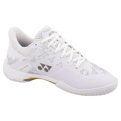 Introducing the Yonex Power Cushion Eclipsion Z3 Men's Badminton Shoes in White and Gold. These stylish shoes boast a patterned design with silver accents and feature the renowned Yonex Power Cushion technology for superior comfort. The lateral shell provides enhanced support, while the textured sole, signature logo on the side, and white laces perfectly round out these stability-focused sports shoes.