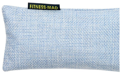 A light blue woven eye pillow showcasing the "Fitness Mad" label in yellow text. The pillow is crafted with a textured, crosshatch fabric infused with active charcoal, serving as the Fitness Mad Sports Odour Absorber to maintain its freshness and appeal.