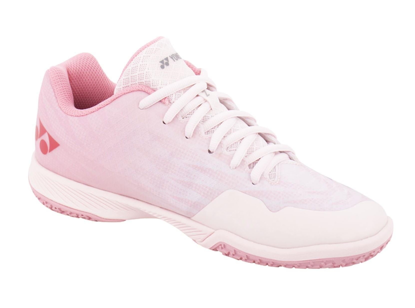 The Yonex Power Cushion Aerus Z2 Women's Badminton Shoes in Light Pink feature a white lace-up design and a subtle logo on the side. They are equipped with a textured sole for enhanced traction, Durable Skin Light for additional support, and a mesh-like upper to ensure breathability, making them perfect for badminton.