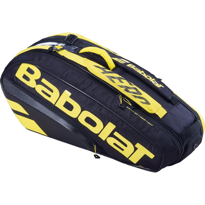 The Babolat RH6 Pure Aero 6 Racket Bag - Black / Yellow is equipped with various compartments, including a transparent shoe section and an insulated area. Adorned with the prominent Babolat logo, it boasts sturdy handles and a sleek design, making it ideal for effortlessly carrying tennis rackets and equipment.