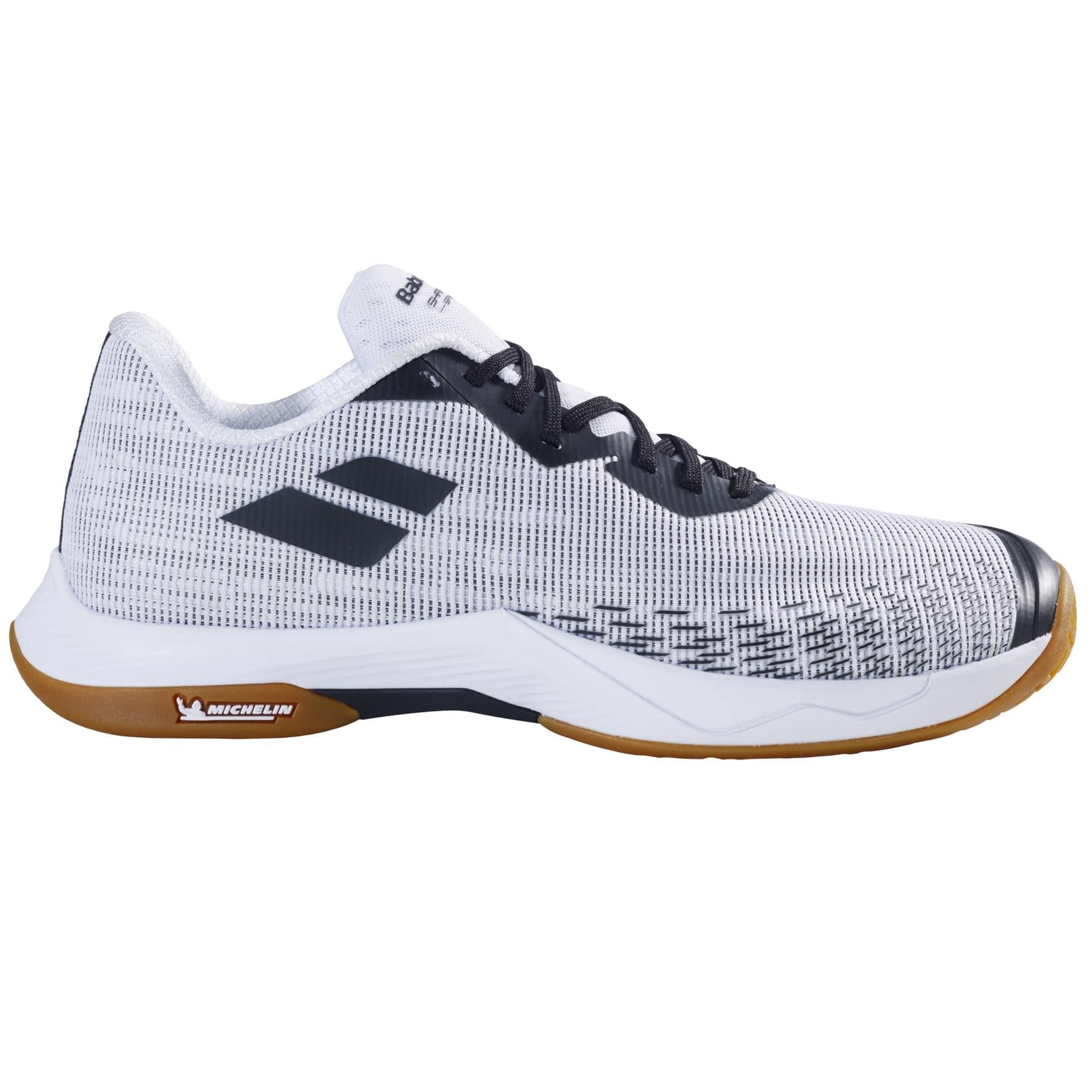 The Babolat Shadow Spirit 2 Men's Badminton Shoes combine an elegant white and gray design accented with black details and feature a textured pattern with the Babolat logo on the side. The brown sole, marked with the iconic "Michelin" branding, ensures superior grip and durability.