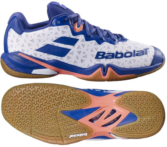 The Babolat Shadow 4 Men's Badminton Shoes in white, blue, and navy are shown from side and sole views, featuring a mesh upper, bold logo, and textured non-marking gum sole—ideal for badminton players.