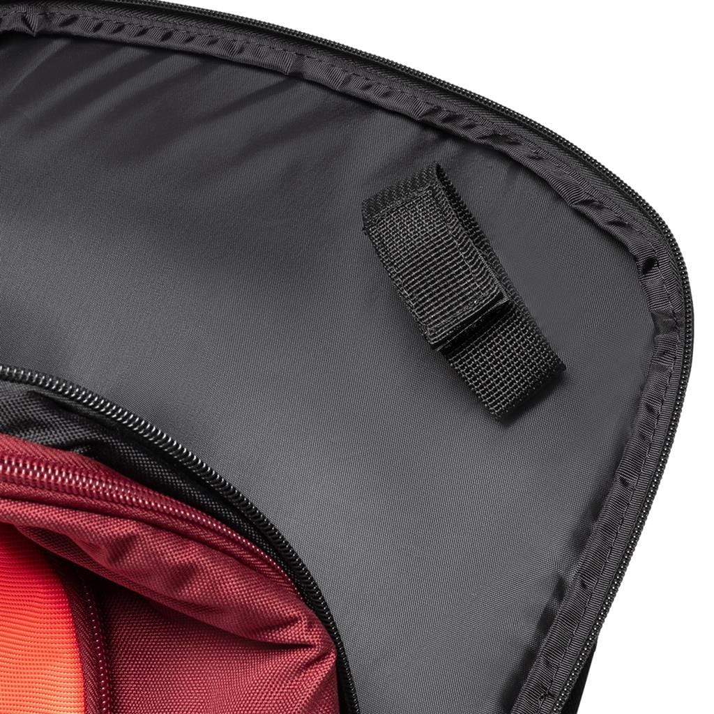 Close-up of an open Dunlop CX Performance Badminton Backpack in black and red, highlighting its interior. It features a red compartment lining ideal for organizing gear and a flap with a black strap. The partially visible zipper along the edge enhances its functionality as an efficient badminton rackets holder.