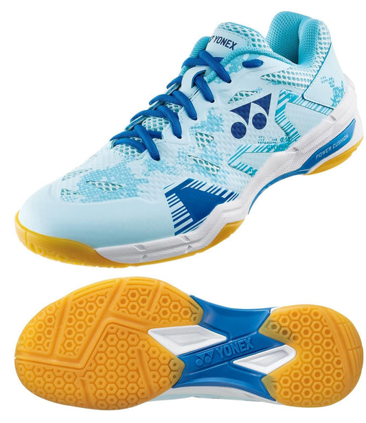 The Yonex Power Cushion Eclipsion X3 Men's Badminton Shoes in light blue showcase a design with darker blue and white patterns. They come with blue laces, a brand logo on the side, and have striking orange and white soles. The label "YONEX" is featured on both the heel and sole. Enjoy exceptional comfort with Yonex Power Cushion technology.