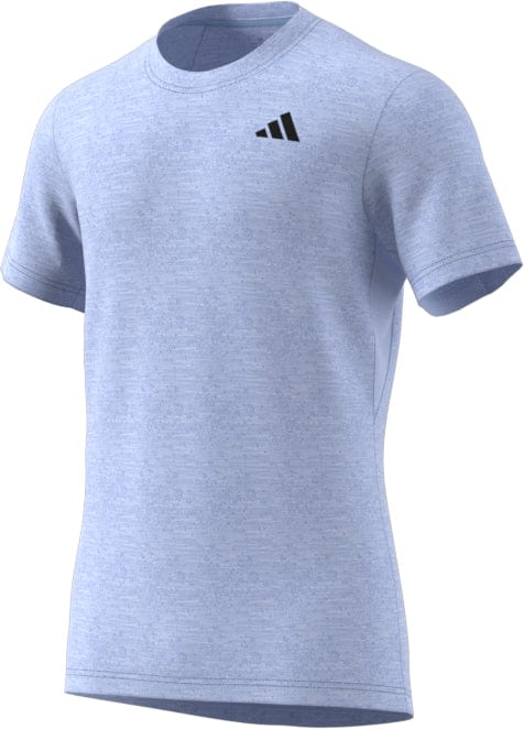 The Blue Dawn ADIDAS Mens Freelift Badminton T-Shirt, crafted by adidas for improved mobility, showcases short sleeves and a discreet black logo on the left chest. The material offers a subtle heathered texture and incorporates AEROREADY technology. Presented against a plain white background, it's ideal for badminton enthusiasts.