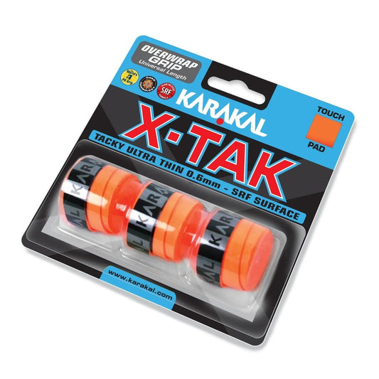 The packaging for the Karakal X-TAK 3 Pack Badminton Overgrips in orange prominently displays the brand name "Karakal" on vibrant orange grip strips. It features specifications such as a "0.6mm - SRF Surface" for excellent tackiness, along with attributes like "Touch," "Pad," and a "Universal Length" ideal for badminton overgrips.