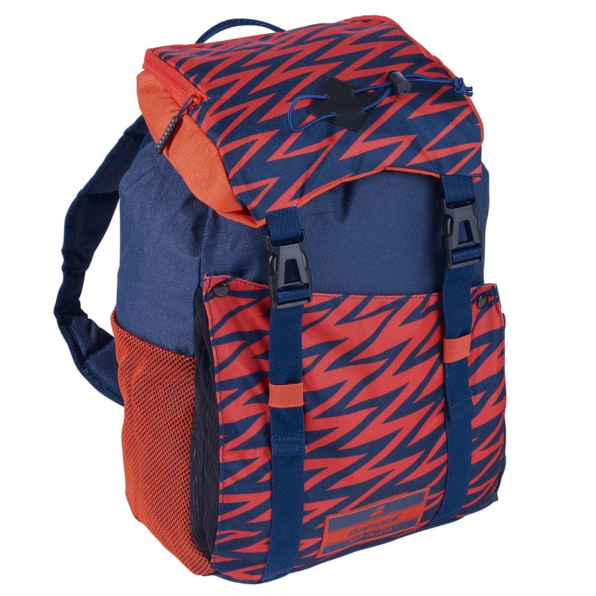 The Babolat Junior Classic Backpack - Blue / Red, crafted by Babolat from recycled PET, showcases a bold design with blue and red zigzag patterns on the flap and bottom. It features orange side pockets, black clip buckles, and adjustable straps. The combination of solid blue areas with patterned sections makes it perfect for future stars seeking a vibrant look.