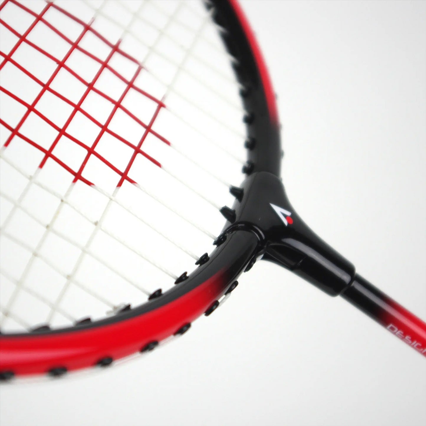 Close-up of the Karakal CB-2 2.1 Junior Badminton Racket, showcasing its aluminium head with a striking red and black frame and red strings. The handle features a small Karakal logo. Set against a plain white background, the design and color scheme are prominently highlighted.