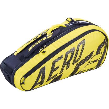 The Babolat RH6 Pure Aero 6 Racket Bag in black and yellow is a stylish accessory featuring the brand name "Babolat" and "Aero." It comes equipped with several zippered compartments, including an insulated section and a clear view shoe compartment, along with a convenient top handle.