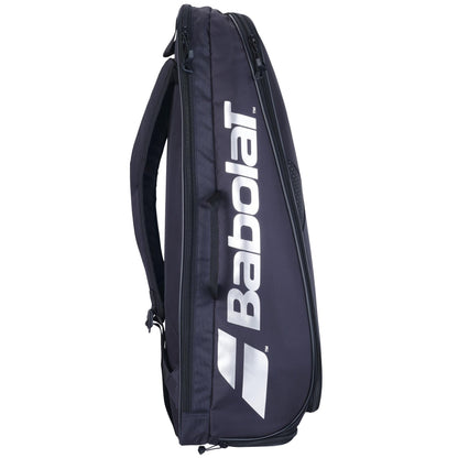 The Babolat Backrack 3 Badminton Bag - Black, expertly designed from recycled polyester, stands upright with a sleek and modern appearance. It prominently displays the crisp white Babolat logo on its side. This multifunctional badminton backpack includes multiple compartments and a secure zippered closure.