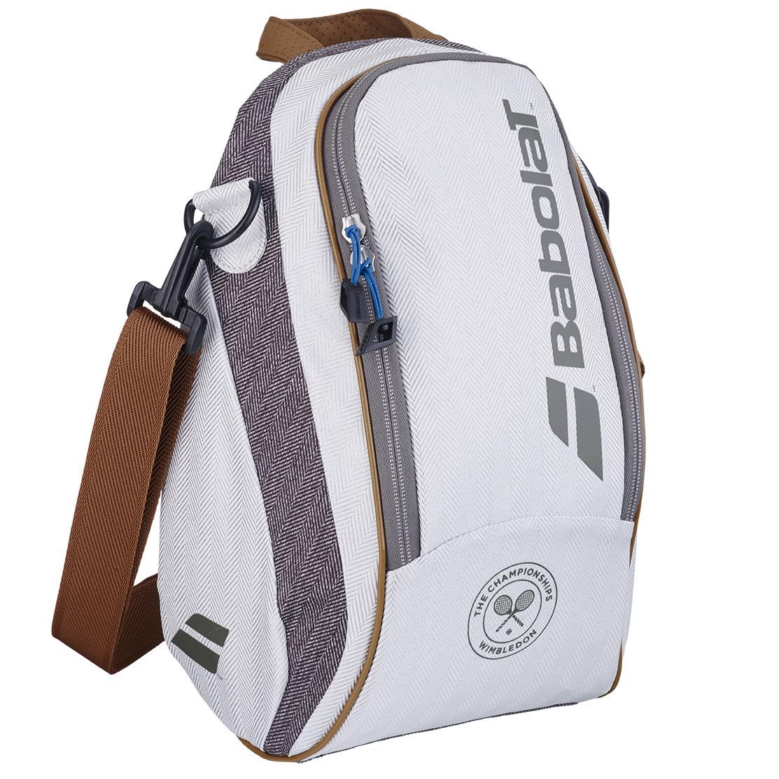 The Babolat Wimbledon Cooler Badminton Bag - Grey is an elegant white and grey carryall with brown straps and zippers, highlighting the iconic Wimbledon colors. It prominently displays the tournament's logo at the bottom, features a textured pattern on the sides, and includes an insulated design to keep contents cool.