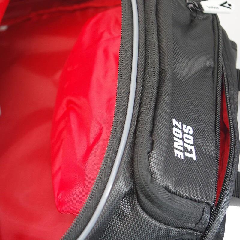 A close-up of an open Karakal Pro Tour 30 2.1 Badminton Backpack in Black/White showcases its red interior with the "SOFT ZONE" label on the exterior. The image highlights the inside pocket and contrasts between the glossy red and textured black fabric, while featuring its padded shoulder straps for enhanced comfort.