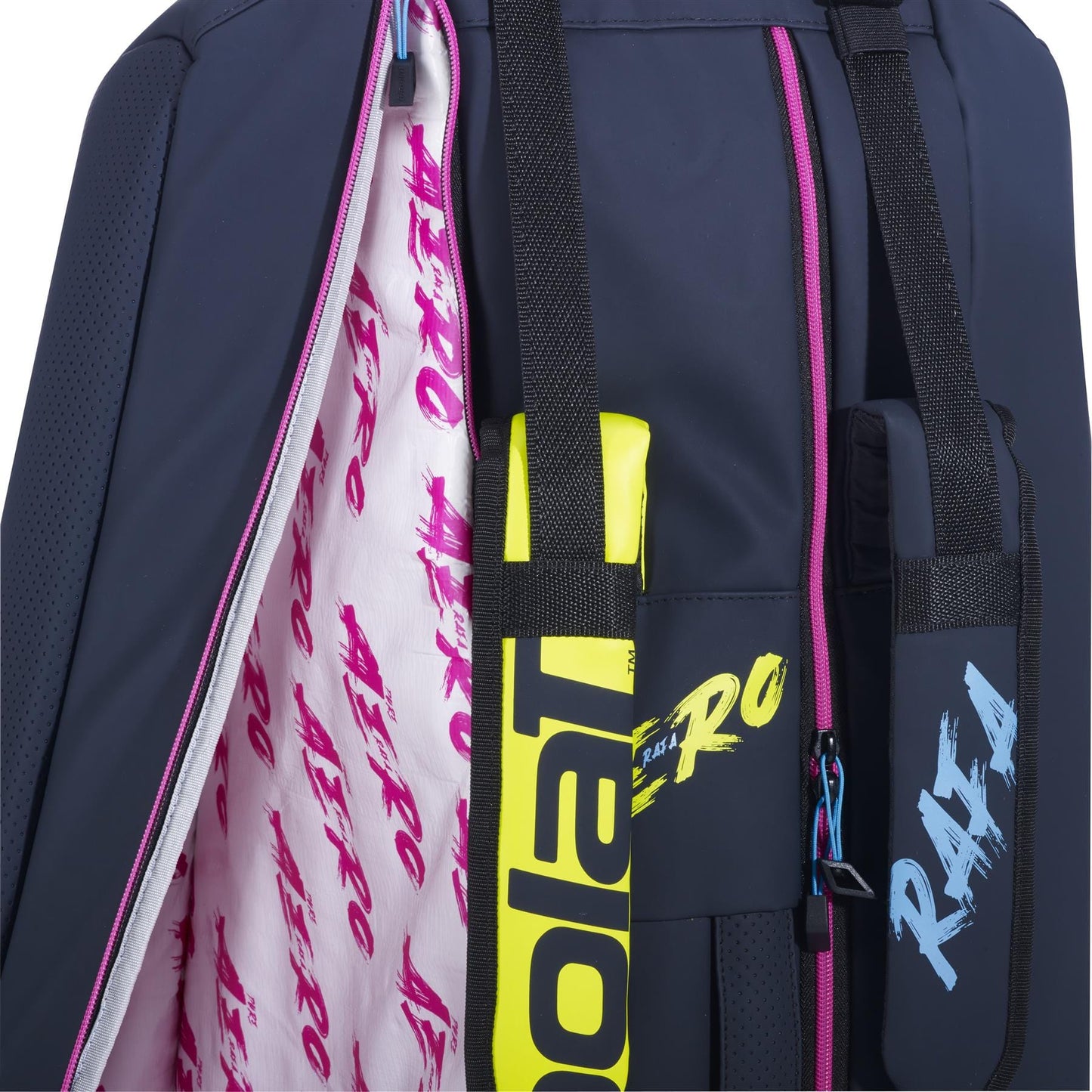 Close-up of the Babolat RH6 Pure Aero Rafa II Badminton Bag, showcasing a navy blue exterior with a vibrant pink interior lining. The bag features colorful "RAFA" script and two black straps with blue "RAFA" text. A neon yellow tennis racket handle complements this insulated racket bag, ideal for keeping gear safe and stylish.