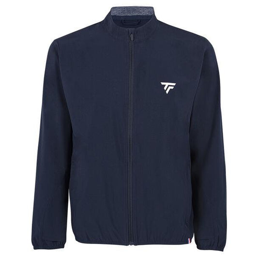 This Tecnifibre Men's Light Badminton Jacket - Marine is a navy blue zip-up with a high collar, long sleeves, and a small white logo on the left chest. It boasts a simple, sleek design and is made from 4-way stretch fabric that is both windproof and water-repellent.