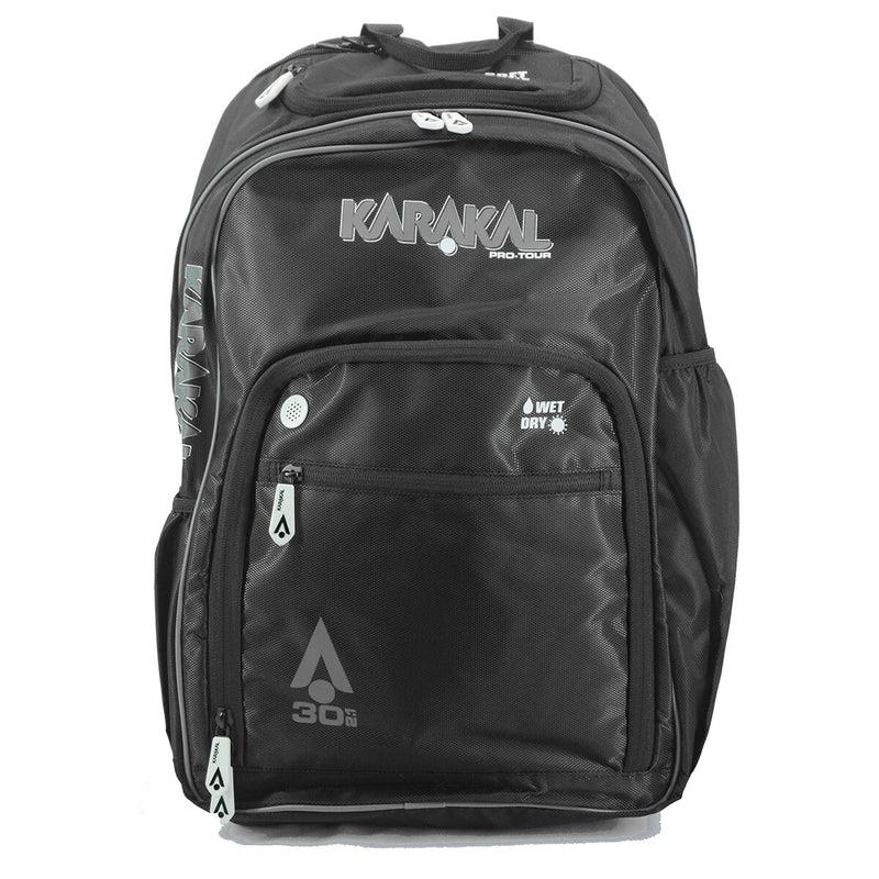 The Karakal Pro Tour 30 2.1 Badminton Backpack in black and white offers multiple compartments with "30L" and wet/dry compartment labels. Its sleek design includes padded shoulder straps, reinforced zippers, and side pockets, making it perfect for sports or travel.