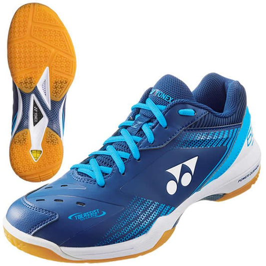 The Yonex Power Cushion 65Z3 Wide Badminton Shoes in Navy Blue are designed with a dynamic combination of blue and white colors, accented by yellow soles and bright blue laces. A prominent logo adds a distinctive touch. These shoes offer exceptional comfort through the Yonex Power Cushion technology and enhance movement with their toe assist shape. The image provides a side view of one shoe alongside the sole of the other, emphasizing detailed design elements and grip pattern.