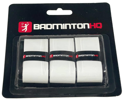 The BadmintonHQ 3 Pack Badminton Overgrips in white feature a black strip adorned with the "BadmintonHQ" logo in red and white text. These overgrips are designed to provide consistent grip performance and include sweat-absorption technology. They are presented on a sleek black cardboard backing covered with clear plastic.