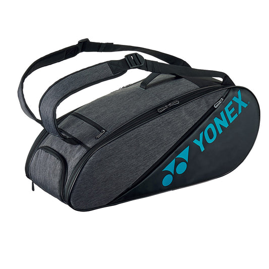 The Yonex 6 Piece Active Badminton Racket Bag 82226 in grey features dual shoulder straps and a zippered compartment, accommodating up to six rackets. The prominently displayed Yonex logo in blue on one side adds a touch of style, making it an ideal choice for any sports enthusiast seeking both functionality and aesthetics.