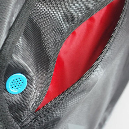 Close-up of a Karakal Pro Tour 30 2.1 Badminton Backpack in black and blue, featuring a gray textured design with an open pocket lined in bright red fabric. The pocket includes a contrasting blue circular vent or button, all within its 30-litre capacity.