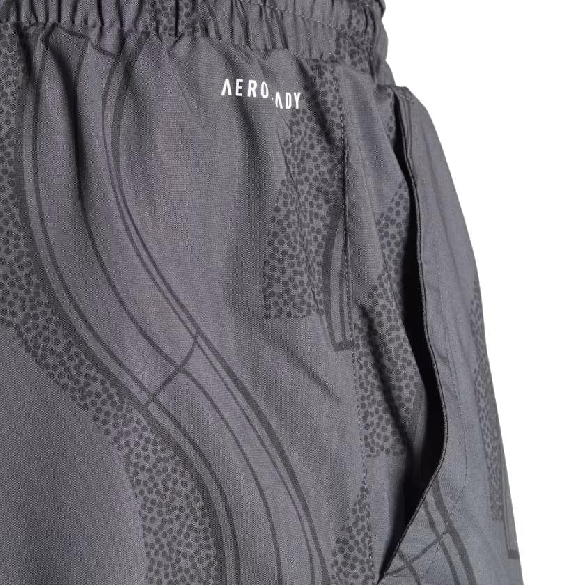 Close-up of the carbon and black ADIDAS Club Graphic Mens Badminton Shorts by adidas, crafted from 100% recycled materials. These shorts display a subtle pattern along with the "AEROREADY" text. Made from lightweight, breathable fabric, they include an elastic waistband and side pockets, offering both functionality and style on the court.