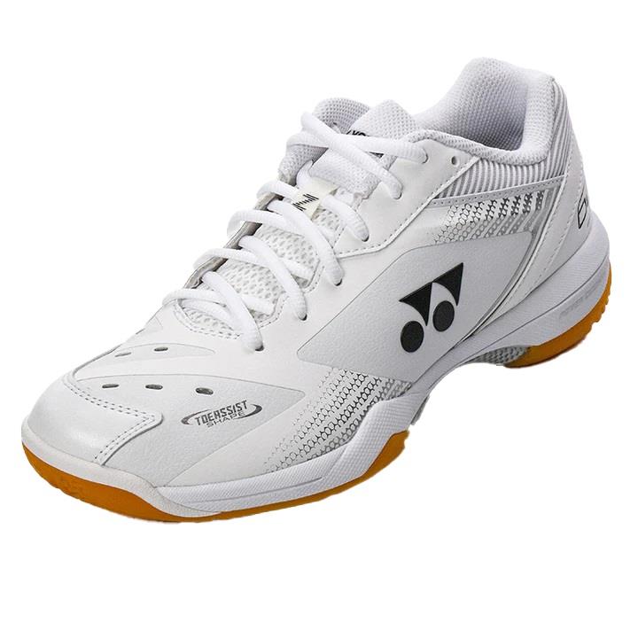 The Yonex Power Cushion 65Z3 Men's Badminton Shoes in white feature orange soles and a black logo on the side, with perforations for breathability. Designed to provide an ultra-comfortable fit, these shoes incorporate Yonex's Power Cushion technology, making them ideal for both sports and casual wear.