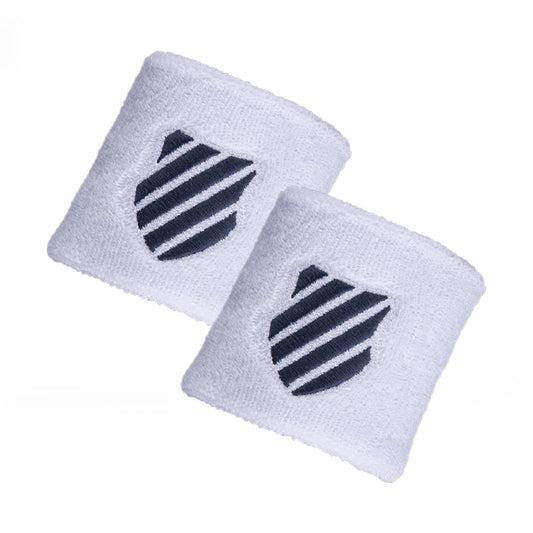 The K-Swiss Wristband, in white and Brunner Blue, features a pair of breathable fabric wristbands adorned with a navy blue shield logo that has diagonal stripes.