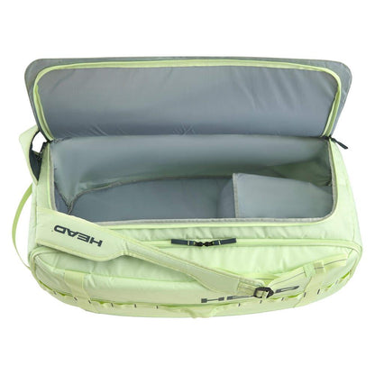 The HEAD Pro Duffle Badminton Bag M - LLAN in light green features a spacious main compartment and a smaller side pocket. Made from durable ripstop fabric, it displays the "HEAD" brand name on the exterior. The bag is equipped with two handles and a partial zipper for convenient access.