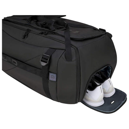 The HEAD Pro X Duffle Bag XL - Black by HEAD is displayed in an elegant black, with a partially open separate shoe compartment revealing white athletic shoes. Equipped with handles and various compartments, this eco-friendly bag utilizes CCT+ climate control technology to keep your gear fresh.