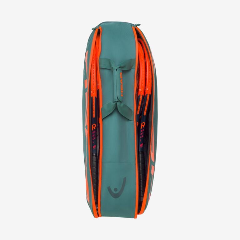 A HEAD Pro Racket Bag - M - DYFO in green and orange stands upright, zippers partially open to reveal 6 racquets inside, making it ideal for club players.