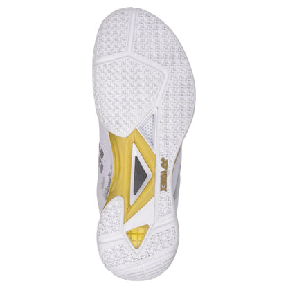 A close-up view of the sole of a Yonex Power Cushion Eclipsion Z3 Men's Badminton Shoe highlights a white textured tread pattern with gold accents and the "Yonex" logo.