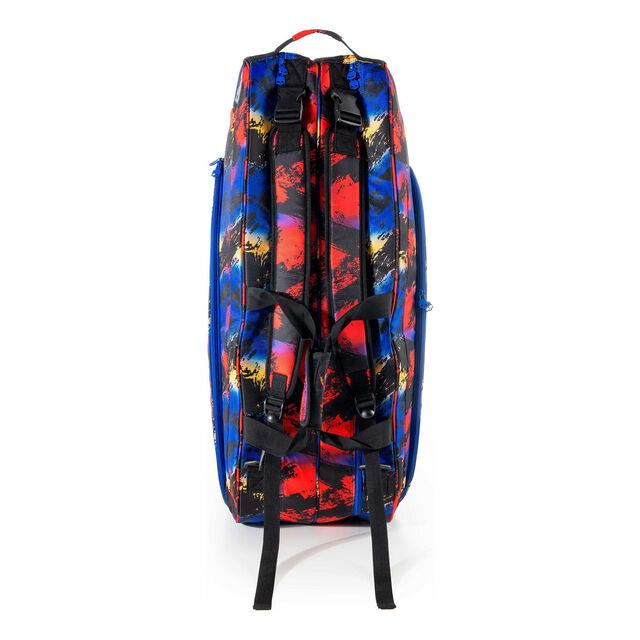 The Prince Hydrogen Random 9 Racket Bag - Blue / Red / Multi boasts a vivid abstract paint splatter design in red, blue, and black. It features adjustable shoulder straps, multiple compartments, and a thermal protective lining for enhanced functionality. The bag stands upright to showcase its side profile.