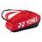 A Yonex 92426EX 6 Racket Pro Badminton Bag in Scarlet, featuring a white logo and text with a black base and blue accents. It includes adjustable shoulder straps and multiple compartments, including a shoe compartment, perfect for carrying your tennis gear.