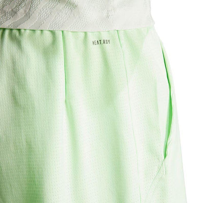 Close-up of the ADIDAS Melbourne Men's 2in1 Badminton Shorts in green, showcasing a subtle dot pattern. Made with recycled materials, these loose-fit shorts feature the "HEAT.RDY" fabric label near the waistband and are designed for comfort during physical activity.