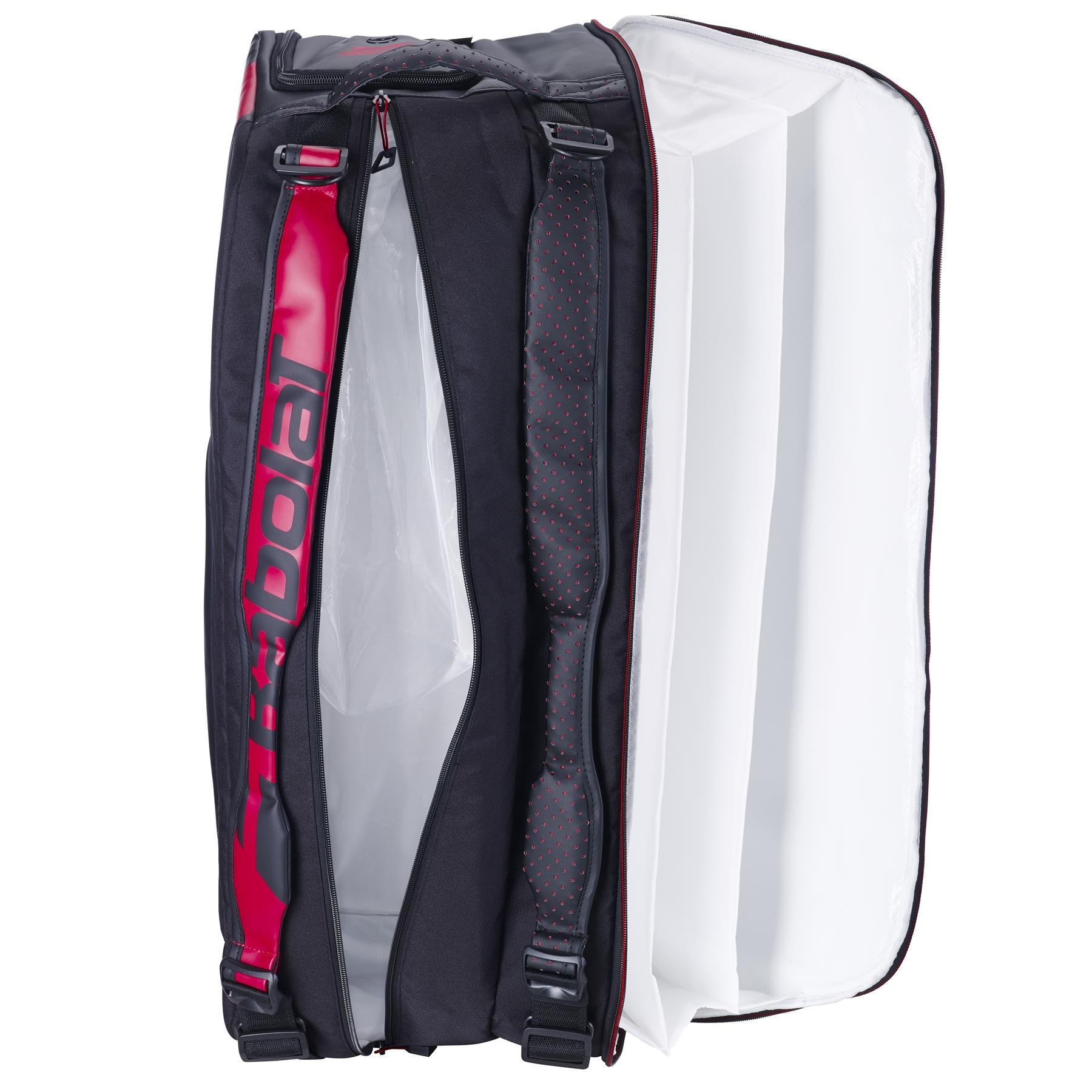 A Babolat Cross Pro Badminton Bag in black and red is displayed open, showcasing its interior design. The inside is white, providing plenty of space for organizing gear, while the exterior prominently displays the Babolat brand name.