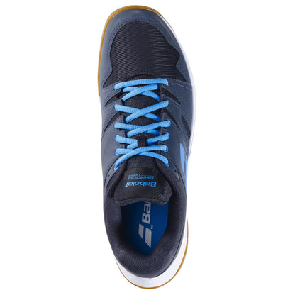 Top view of a single black and grey athletic shoe, crafted as the Babolat Shadow Team 2 men's badminton shoe, complete with light blue laces and featuring a durable white and brown Michelin rubber sole. The shoe prominently showcases the Babolat brand logo on the insole and side.